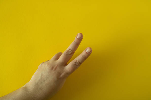 istock Raised two fingers on a woman's hand 1472849485