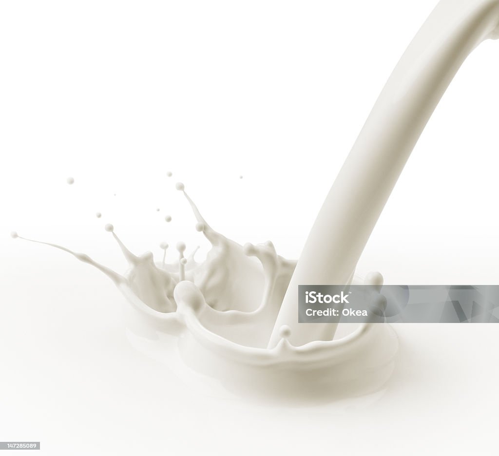 Stream of milk pouring and splashing on surface pouring milk or white liquid created splash Milk Stock Photo
