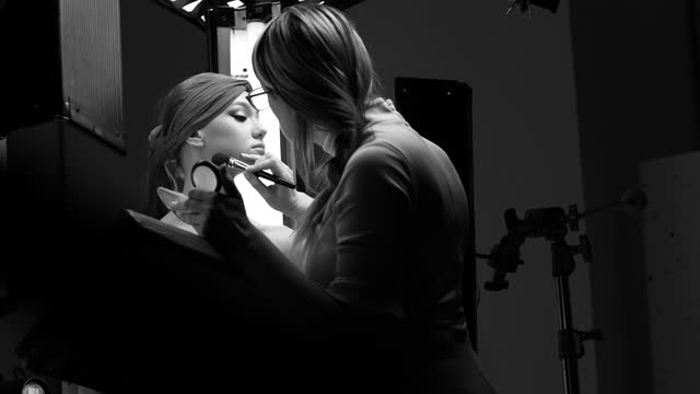 Make-up artist does makeup on the set.