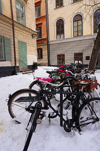 bicycles parked on the side of a building in the city during winter