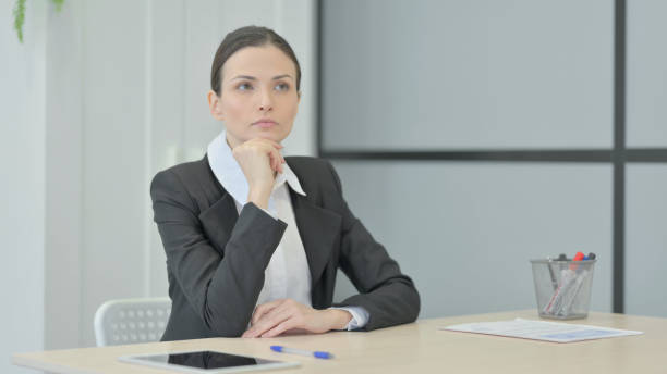 istock Pensive Businesswoman Thinking while Sitting at Work 1472855745