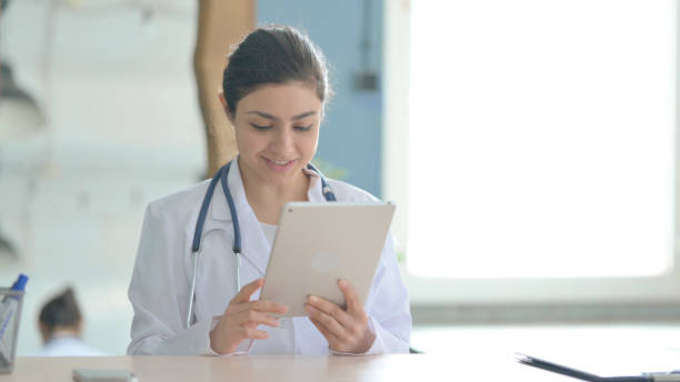 istock Online Video Chat on Tablet by Young Indian Doctor 1472856655