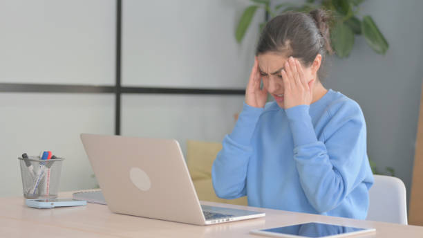 istock Indian Woman having Headache while Working on Laptop 1472858943
