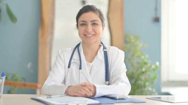 istock Young Indian Doctor Talking Online in Clinic 1472858975