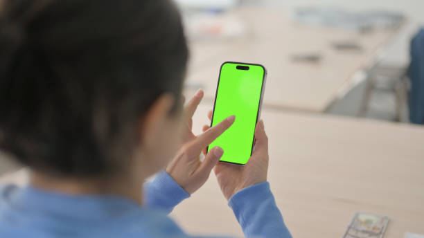 緑のクロマスクリーンで電話を使用するインドの女性 - 13584 ストックフォトと画像