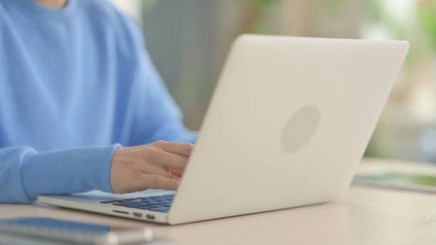 istock Side View of Hands Typing on Laptop 1472859320