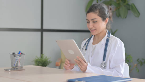 istock Online Video Chat on Tablet by Young Indian Doctor 1472860509