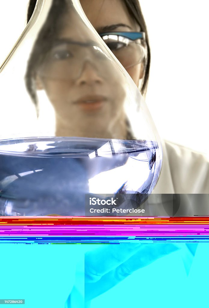 Femmina Scienziato esaminando blu liquido - Foto stock royalty-free di Accuratezza