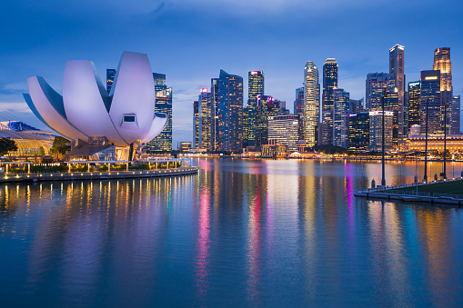The Singapore Downtown City and Marina Bay Business District Skyline at twilight with reflection in the still water.