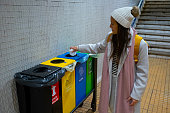 Girl puts waste in recycling bin. Urban sustainability.