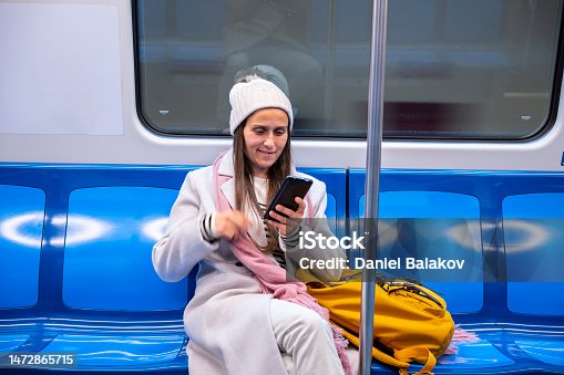 istock Woman with phone travels in the city metro. Urban subway. 1472865715