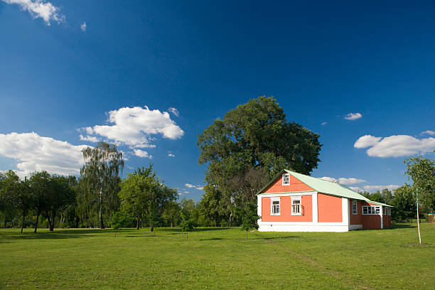 a photo of nice red house and green lawn in the countryside
