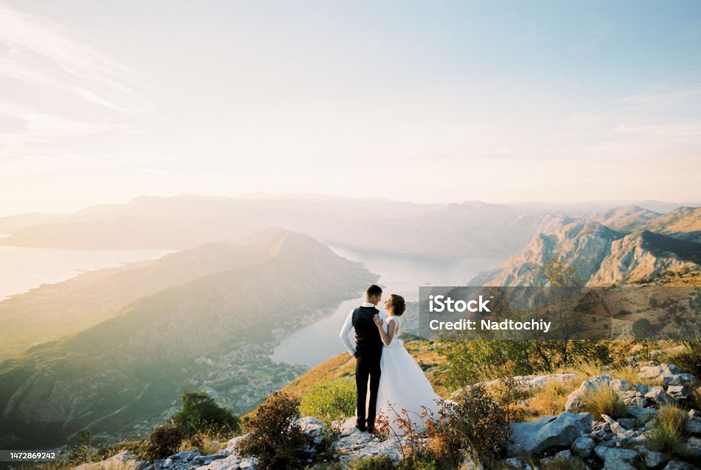 Groom hugs bride on a mountain above the Bay of Kotor Groom hugs bride on a mountain above the Bay of Kotor. High quality photo Wedding Stock Photo