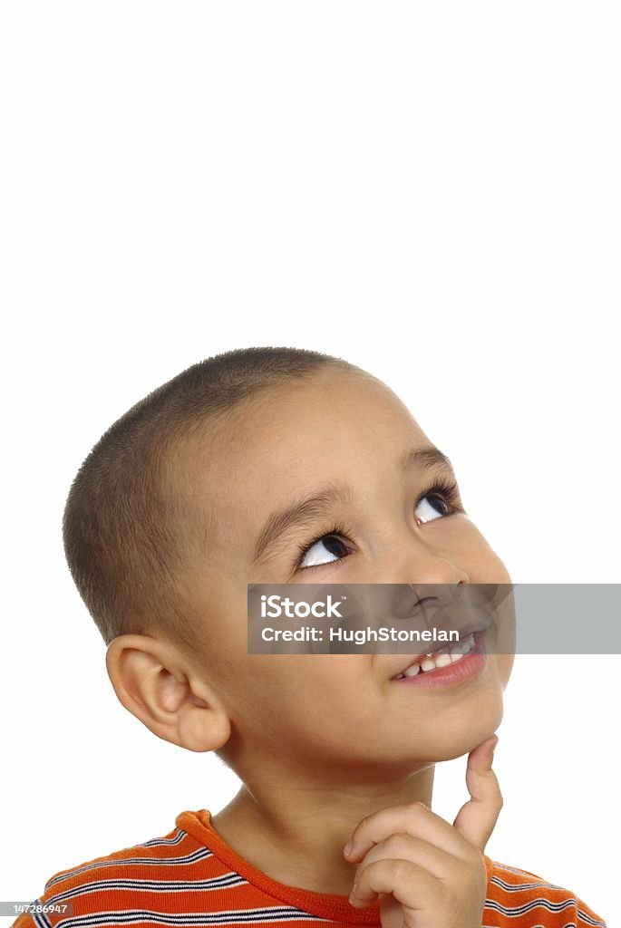 Boy looking up in wonder 5 years old a 5-year-old hispanic boy looking up with a wondering expression and finger on chin, isolated on white background with copy space Boys Stock Photo