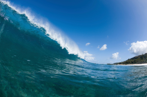 a breaking wave with clear skys in hawaii