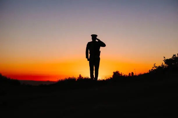Police Officer saluting at sunset