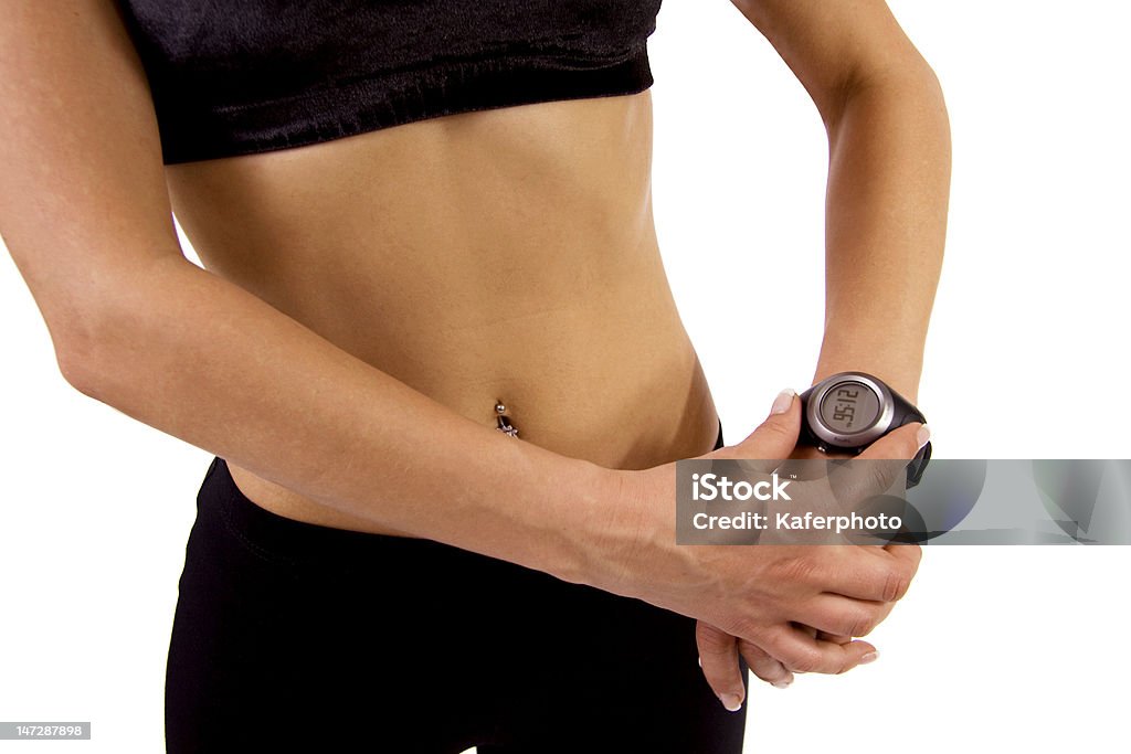 Fitness woman with a GPS watch A woman is programing a GPS watch before going of for a run Adult Stock Photo