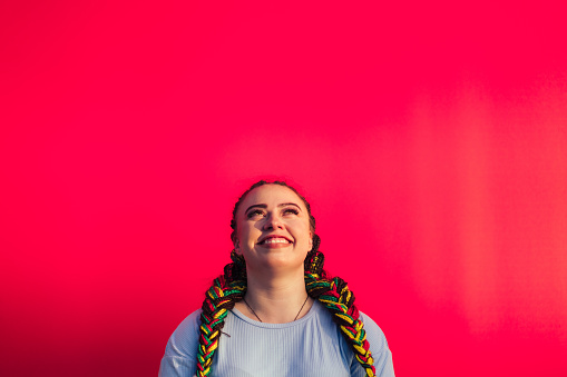 Portrait of young Maori woman against a red background in Auckland, New Zealand.