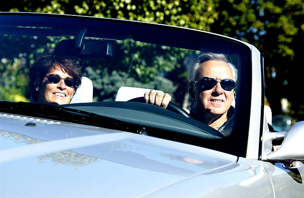 Middle-aged couple in a convertible with sunglasses on stock photo