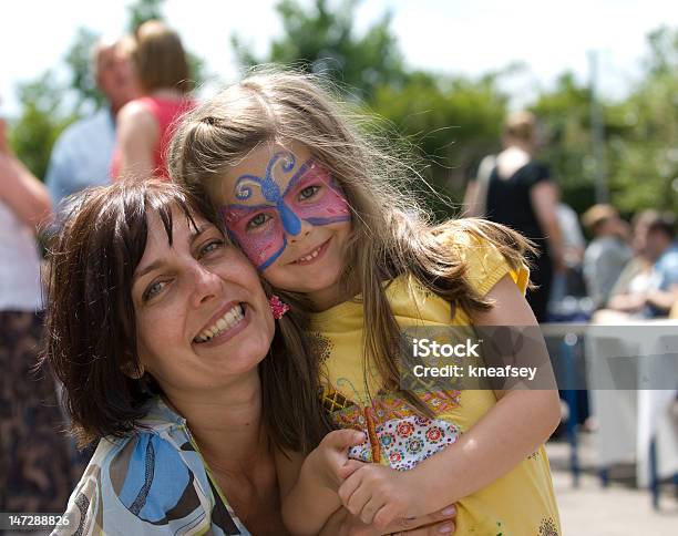 Madre E Hija Con Pintura De La Cara Cuddle Foto de stock y más banco de imágenes de Pintura de cara - Pintura de cara, Niño, Familia