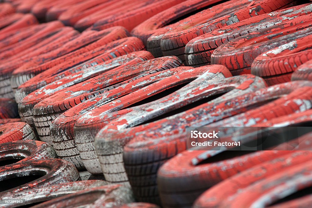 Motorsport Tyre Wall (Red) Battered, painted tyre wall at Silverstone motor racing circuit, Northamptonshire. Ideal for a motorsport background. Silverstone Stock Photo
