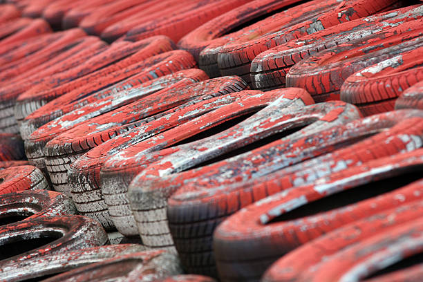 Motorsport Tyre Wall (Red) Battered, painted tyre wall at Silverstone motor racing circuit, Northamptonshire. Ideal for a motorsport background. silverstone stock pictures, royalty-free photos & images