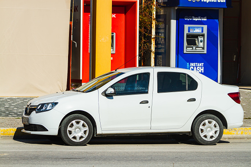 Side, Turkey -January 23, 2023:     white Renault Symbol   is parked  on the street on a warm  day against the backdrop of a buildung, shops