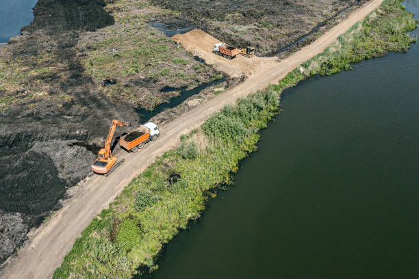 istock construction machinery on construction site. excavator loads soil into a truck. aerial view from flying drone. 1472896346