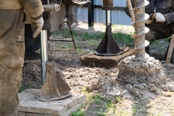 ein team von arbeitern mit bohrgerät auf dem auto bohrt artesischen brunnen nach wasser im boden. einbringen eines metallgehäuserohrs in den boden, installation einer individuellen trinkwasserversorgung, 28. juni 2022, russland, - casing stock-fotos und bilder