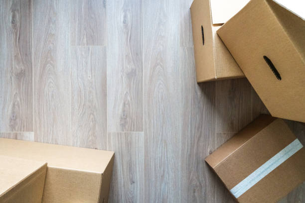 Stack of cardboard boxes at empty residential apartment. Moving home concept. Directly above view.
