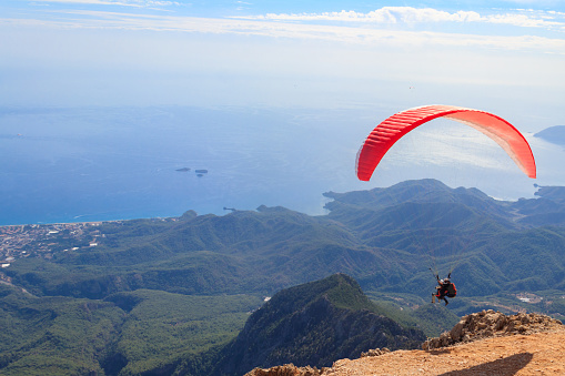 Antalya Province, Turkey - October 23, 2020: Paragliders flying from a top of Tahtali mountain near Kemer, Antalya Province in Turkey. Concept of active lifestyle and extreme sport adventure