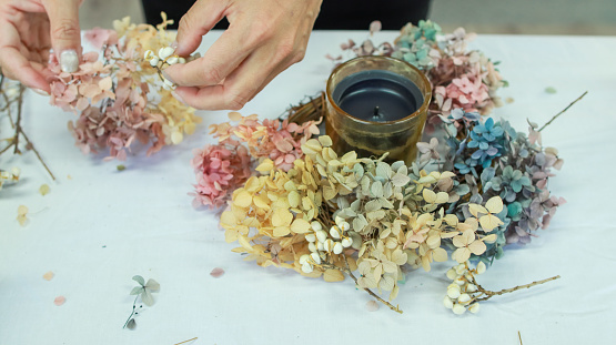 A female floral teacher is making a wreath using preserved hydrangeas