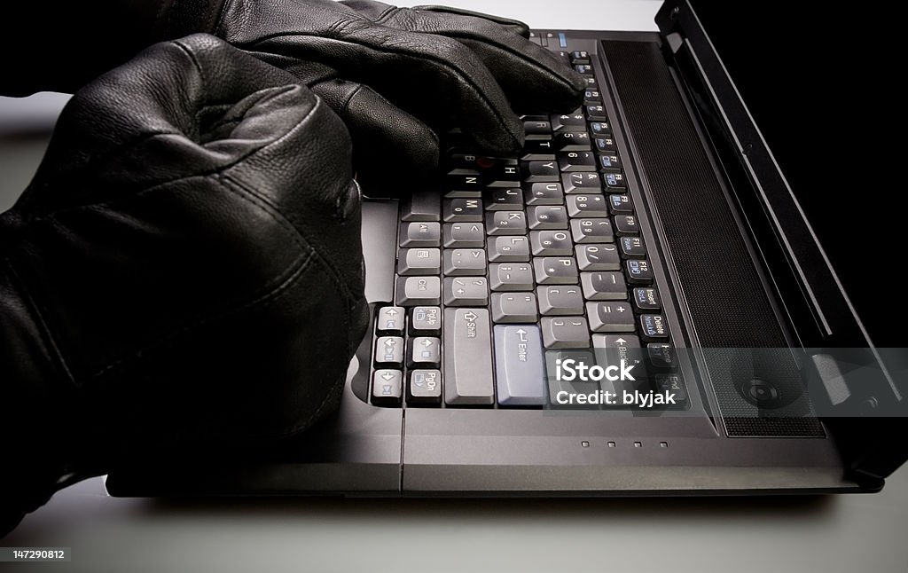 Mad hacker working on laptop at night Security concept with mad hacker working on laptop at night. Black Color Stock Photo
