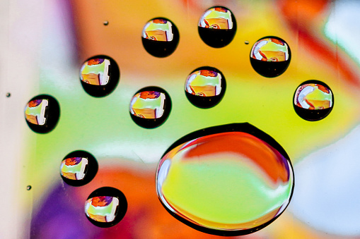 Cloesup photo of water droplets against a colour background