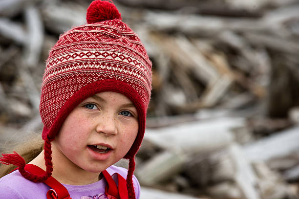 girl in stocking cap beach combing stock photo