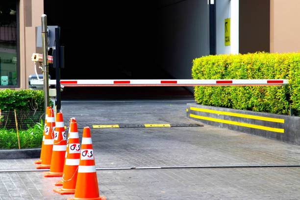 istock security system for building access - barrier gate stop with toll booth, traffic cones and cctv 1472921380