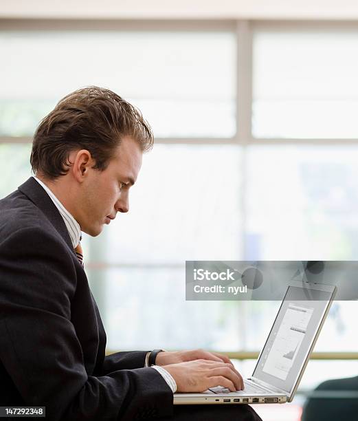 Hombre De Negocios Trabajando En La Computadora Portátil Foto de stock y más banco de imágenes de Vista de costado
