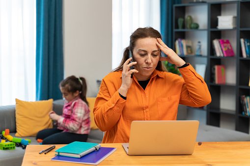 Busy mother working from home with daughter