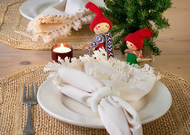 This casual winter place setting includes straw place mats, cream colored plates and napkins, and two charming little skiers.