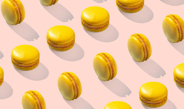 istock Lemon yellow macarons on invisible background isolated with hard shadows 1472926304