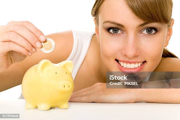 Woman Putting Coin In Piggy Bank Stock Photo - Download Image Now - Adult, Banking, Beautiful People