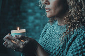 One woman indoor at home, lights candles, enjoy meditation, do yoga exercise at home. Mental health, self care, No stress, healthy habit, mindfulness lifestyle, anxiety relief concept. Religion faith