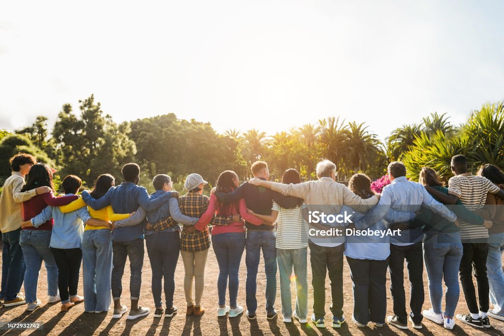 Group of multigenerational people hugging each others - Support, multiracial and diversity concept - Main focus on senior man with white hairs Community Stock Photo