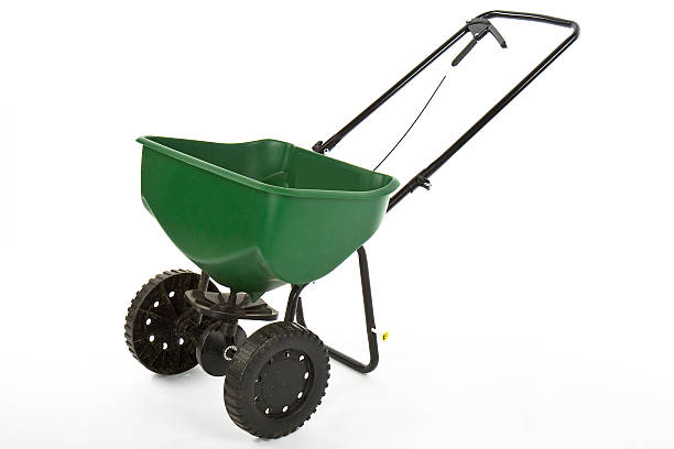 seed fertilizer spreader Green seed/fertilizer spreader on white background lawn seeder stock pictures, royalty-free photos & images