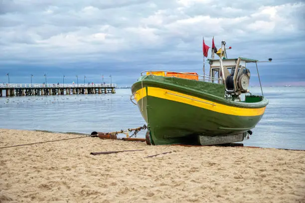 Evening cloudy beach on the Baltic Sea and colorful old fishing boats.
 Leisure and tourism in Gdynia