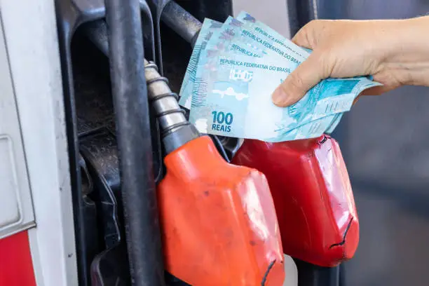Photo of Brazil, gas station woman holding a handful of money, concept, gas station prices, refueling cars, fuel costs