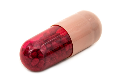 Red capsule on white background.