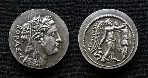 Ancient Greek coin of Agathocles, tyrant of Syracuse, Sicily. Tetradrachm with portrait of Persephone (Kore) and winged goddess Nike, macro view. Theme of old rare coin, money, Greece and history.