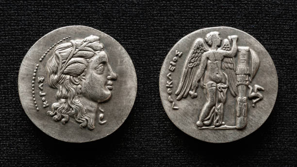 古代ギリシャの硬貨、人間の肖像画と翼のある神を持つお金のマクロビュー - 古代 ストックフォトと画像