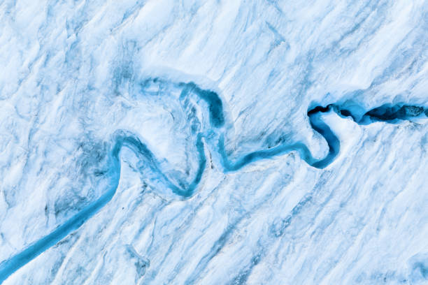 An aerial view of an iceberg and river. Winter landscape from a drone. View of the moraines. Landscape from the air. River on a moraine. stock photo
